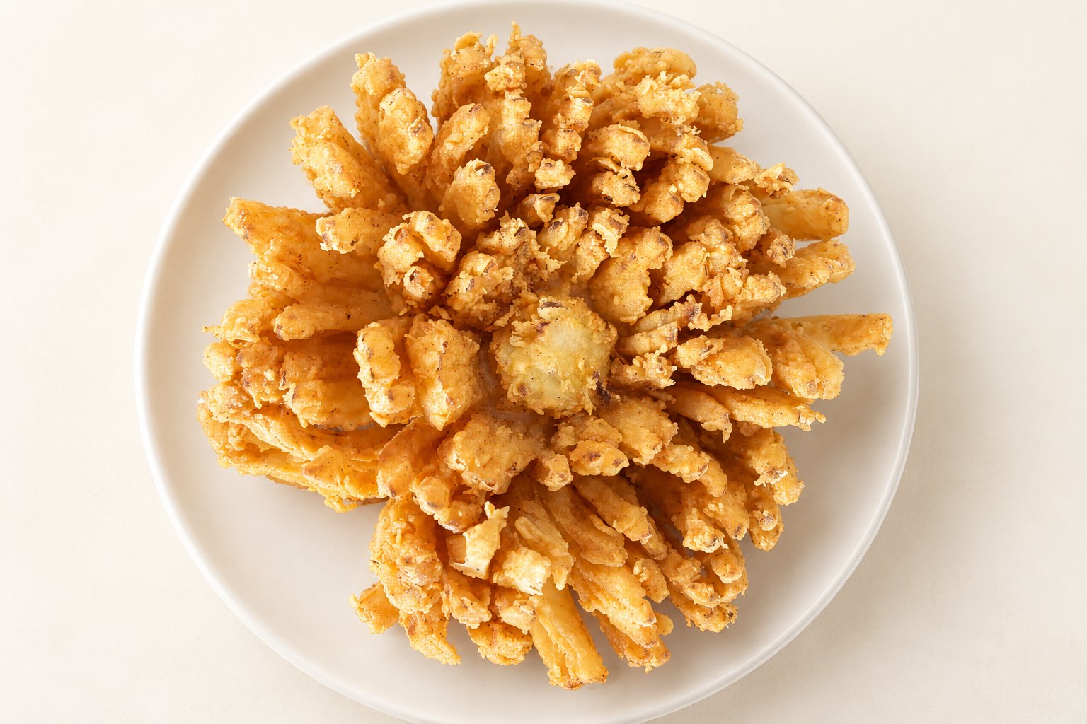 Golden coated blooming onion with attached petals, enhanced from the supplied sample photo
